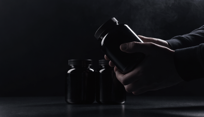 Beginnende sporter bekijkt drie supplement producten op donkere achtergrond, obsidian merkstijl