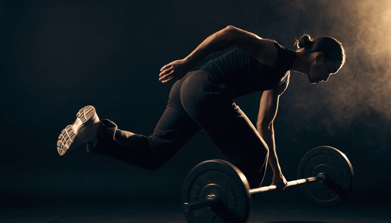 Atleet in overgang van hardlopen naar krachttraining, donkere obsidian sportschool sfeer