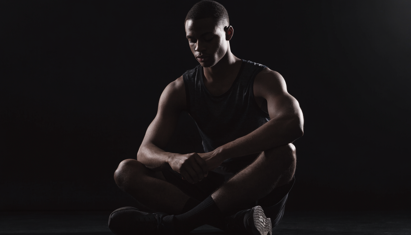 Atleet mediteert rustig na een training in een donkere rustige ruimte, obsidian sfeer